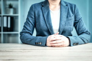 Businesswoman with arms clasped on table